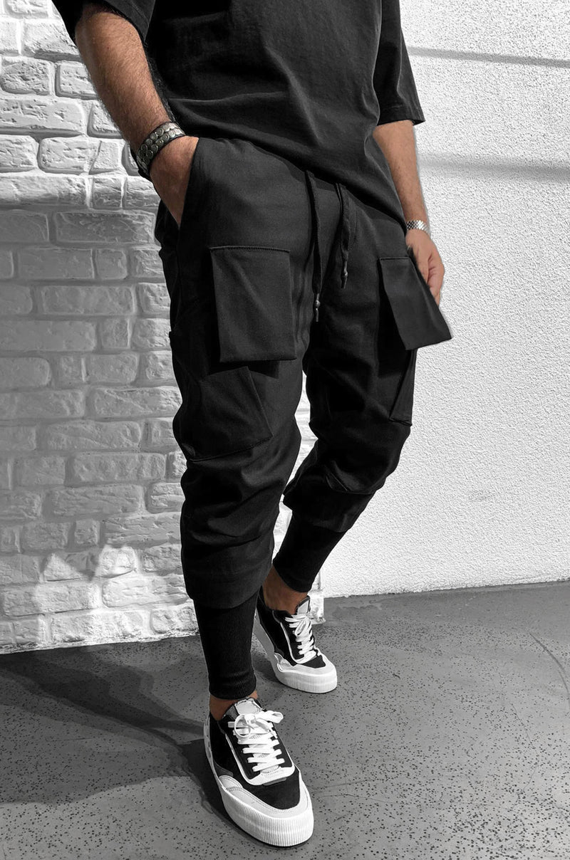 Hose aus Funktionsstoff von Black Island mit elastischem, verstellbaren Bund. Aufgesetzte Vordertaschen. Elastischer, eng verlaufender Beinabschluss.    Unser Model trägt Größe L.   Körperlänge: 180 cm (5.91 ft)  Gewicht: 77 kg (169,76 lbs)   Farbe: Schwarz  Material: 100% Polyeste